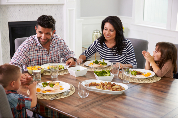 SU - Hispanic Family Enjoying Meal At Table Hispanic Family Enjoying Meal At Table