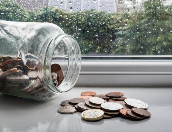 SU - Jar of english money with rainy day background Jar of english money with rainy day background