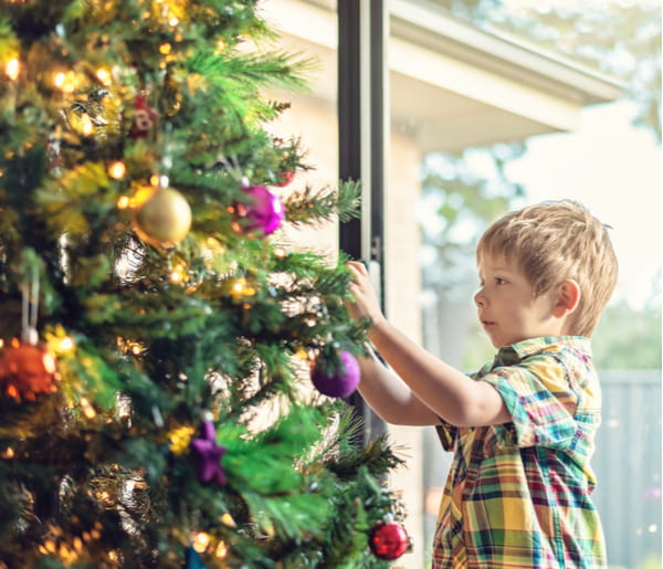 Cute little boy decorating a Christmas tree