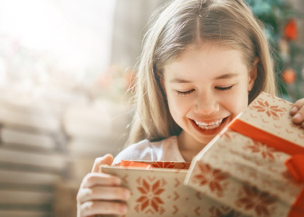 StepUp - Gwtting presents on Christmas Happy girl child opening gift at Christmas