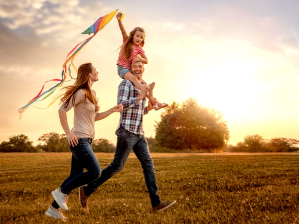 SU - Protect yourself Family running through field letting kite fly