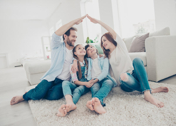 Happy family inside a home sitting on the floor