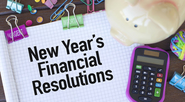 New Year's Financial Resolutions written on a pad with clips, calculator and piggy bank