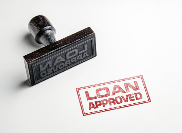 Loan Approved stamped on a pad with rubber stamp beside