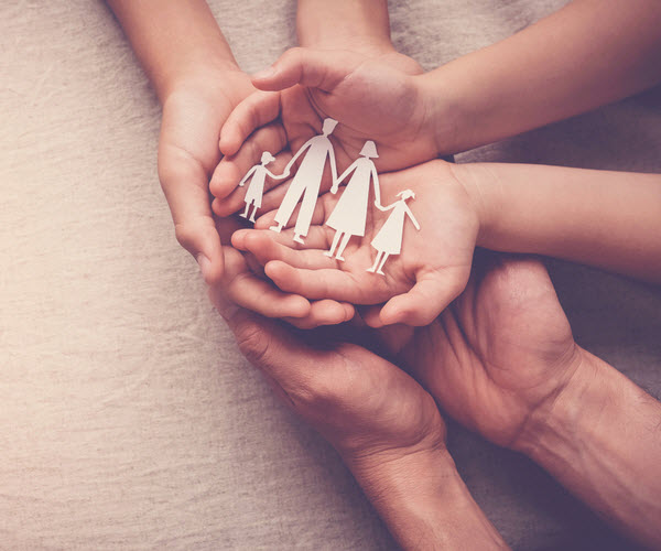hands holding paper family cutout