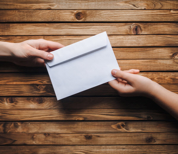 Step Up - Gifting money White small envelope in the hands of two people