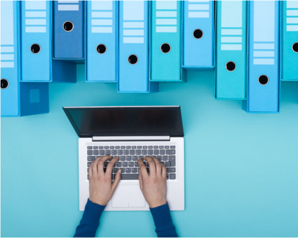 SU - Check the Basics Organized archive with ring binders and woman searching for files in the database using a laptop, top view