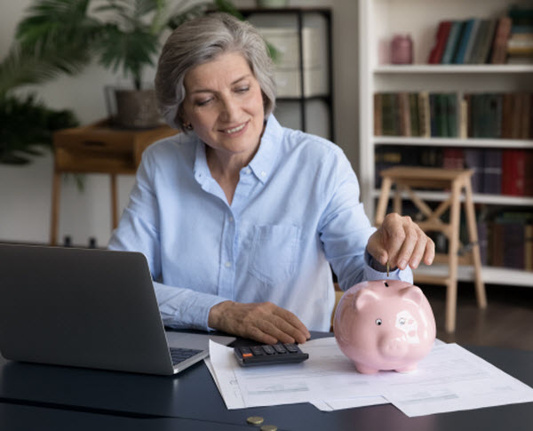 Step-Up-Personal super contribution Happy middle-aged woman put coin into piggybank, save money for future