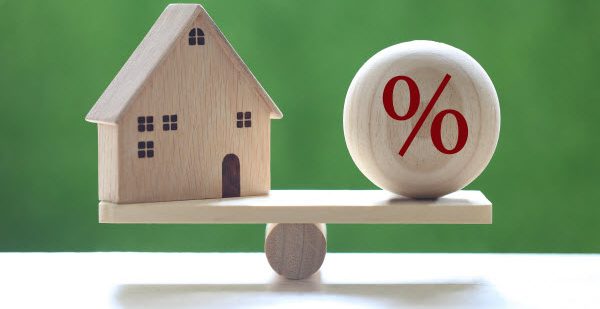 Step Up Group - Check mortgage rates Interest rate up and Banking concept, Model house with Percentage symbol icon on wood scale seesaw on natural green background