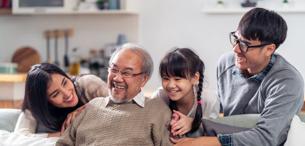 Happy multigenerational family sitting on a couch in living room