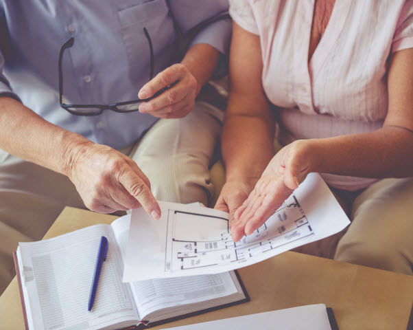 man and woman discussing house project while sitting on couch at home