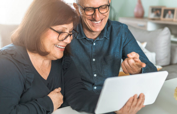 Senior couple happily looking at the tablet