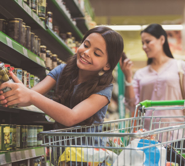 Little girl holding an item inside a supermarket with her mother