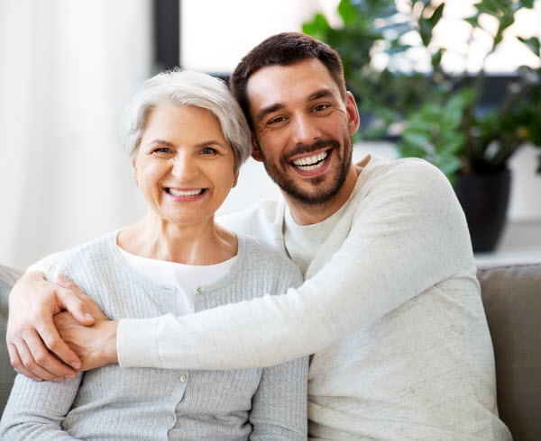 Step Up - Getting on property ladder happy smiling senior mother with adult son hugging at home