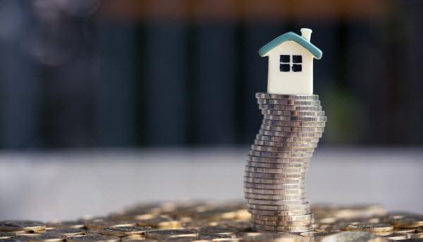 Step Up - Property ladder in a tough financial climate House model on coins stack