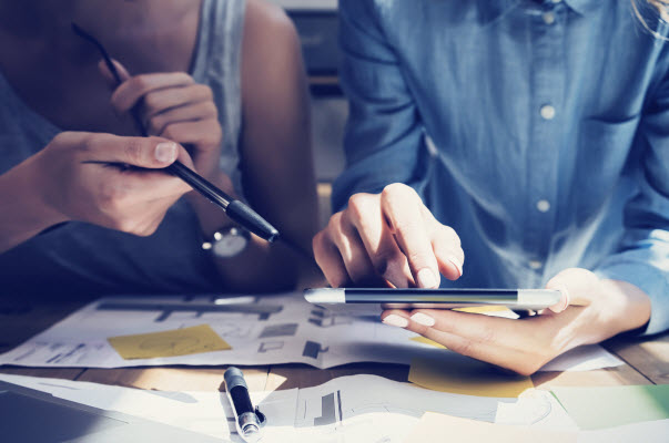 Step Up - Strategy in property purchase Colleagues discussing while checking something using the tablet