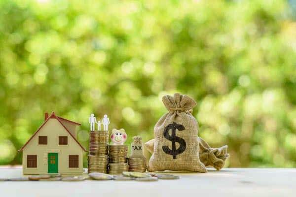 Bag with dollar sign, stacked coins and miniature house