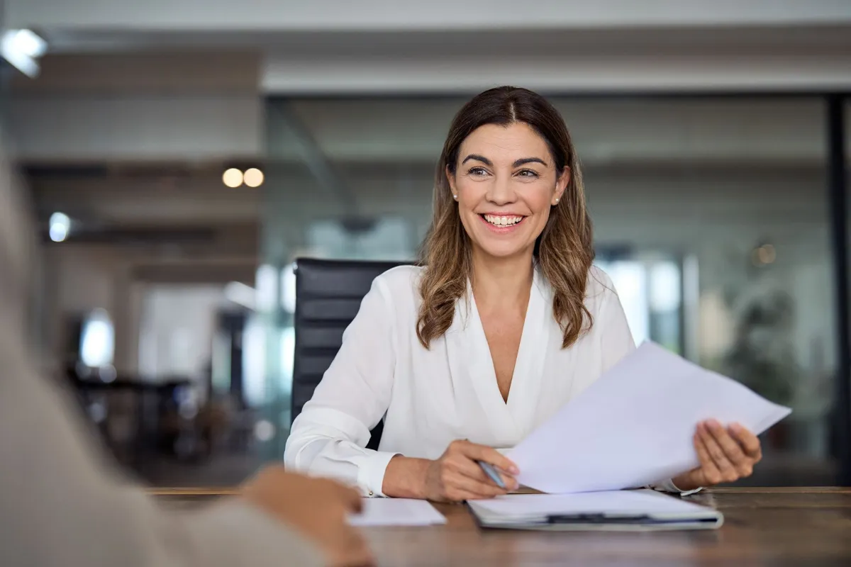 Smiling mature business woman holding a piece of paper
